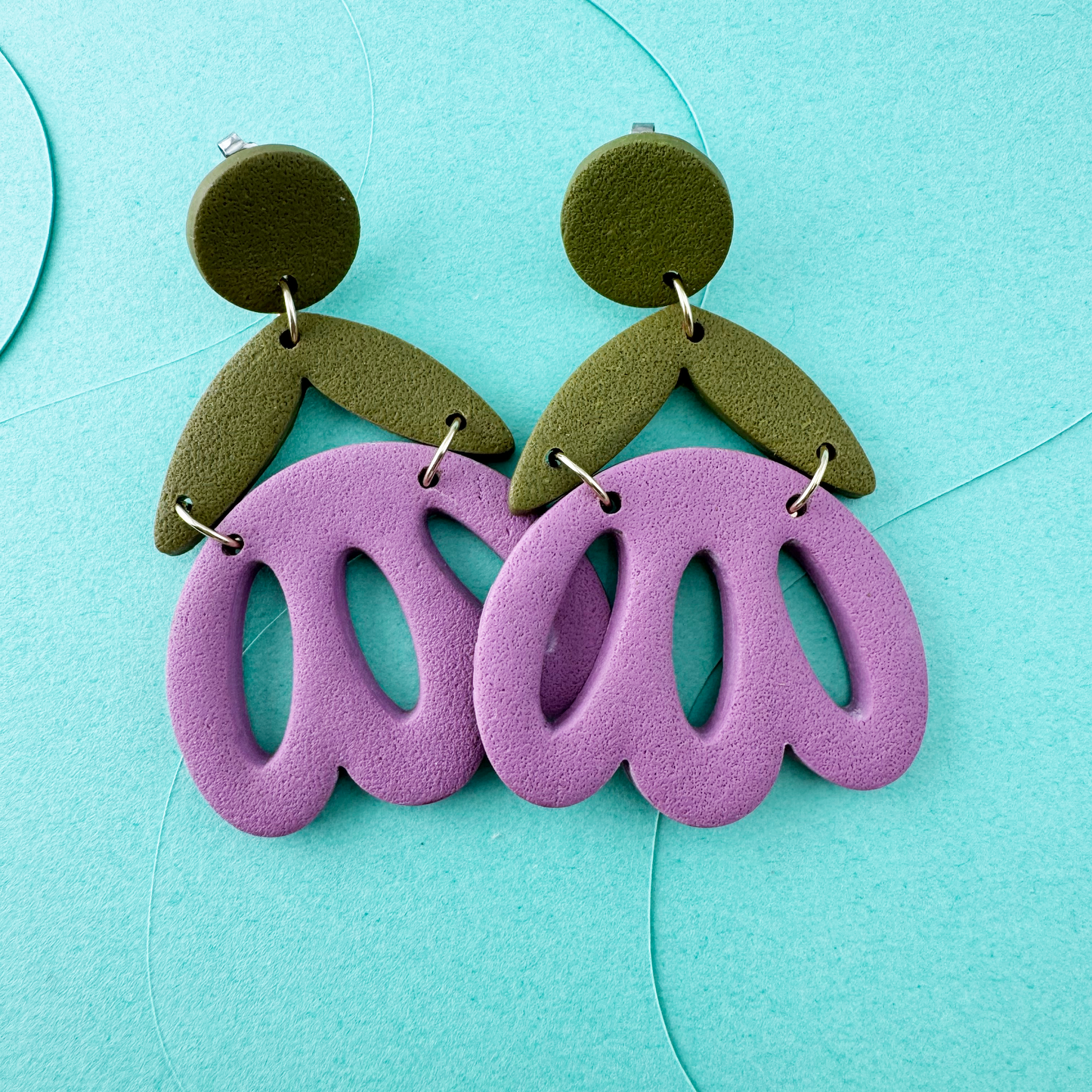 Pinky purple pastry shaped tulips connected to olive green leaves, and olive green posts.